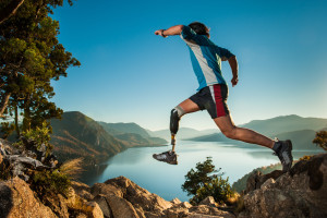 Hombre lisiado saltando en la montaña